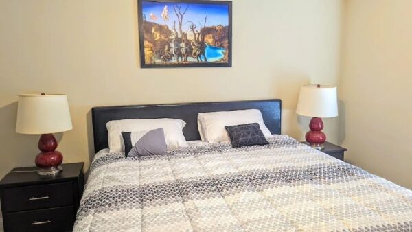 a bed with white and gray sheets