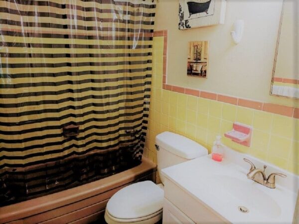 a restroom with striped shower curtains